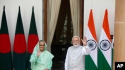 Indian Prime Minister Narendra Modi, right, and his Bangladeshi counterpart Sheikh Hasina wave to the waiting media before their delegation level talks in New Delhi, India, Tuesday, Sept. 6, 2022. 