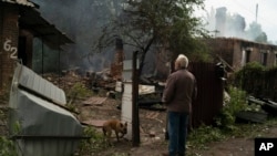Oleksander Zaitsev, 67, stands in front of the house where his friend was found dead after a Russian attack in Pokrovsk region, Ukraine, Sunday, Sept. 11, 2022. (AP Photo/Leo Correa)
