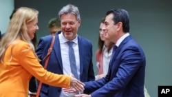 European Commissioner for Energy Kadri Simson, left, greets Greek Energy Minister Constantinos Skrekas, right, and Germany's Energy Minister Robert Habeck, center, during a meeting of EU energy ministers in Brussels, Friday, Sept. 9, 2022. (AP Photo/Olivier Matthys)