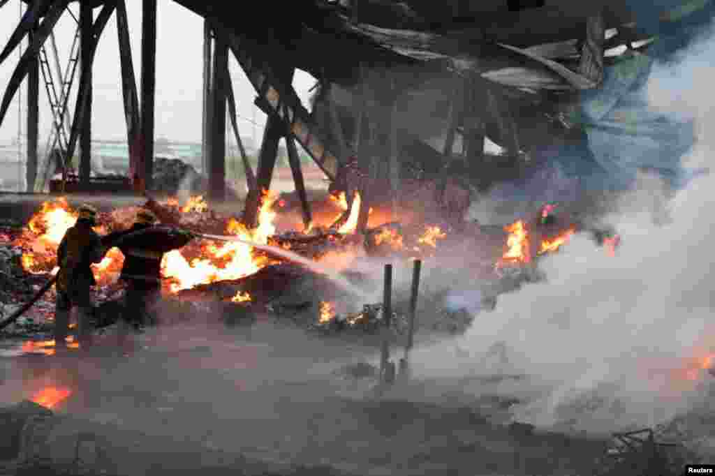 Specialists work to extinguish fires following an explosion at a warehouse near an airport in Tashkent, Uzbekistan, in this picture released by the government of Uzbekistan.