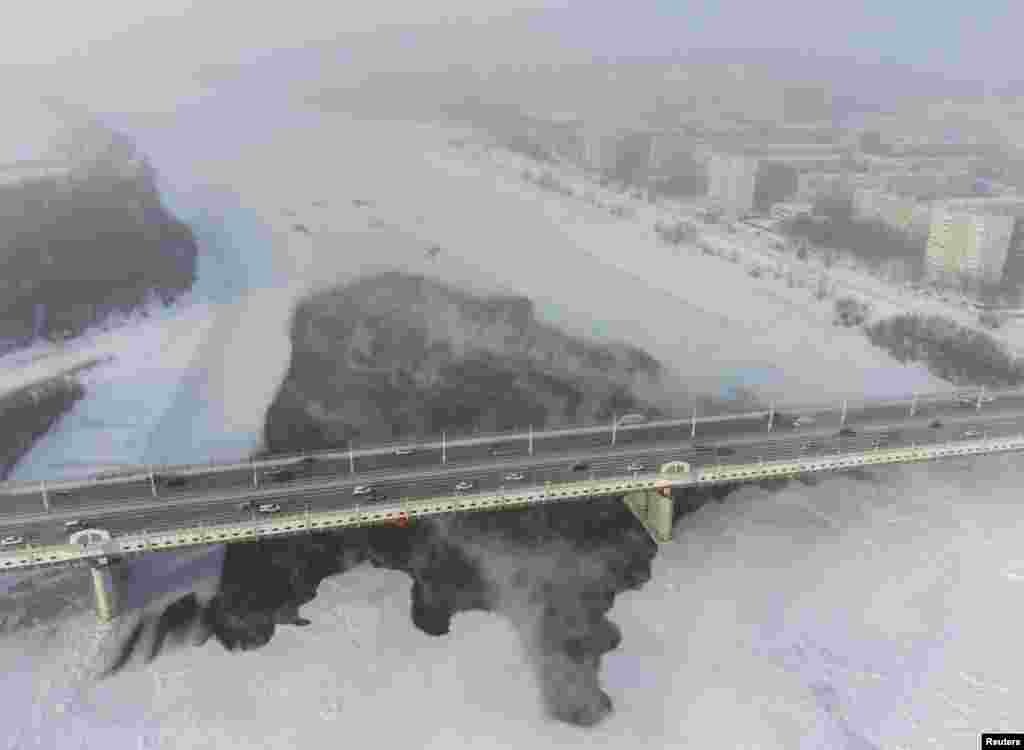 Cars drive on the bridge over the Irtysh River in Omsk, Russia.