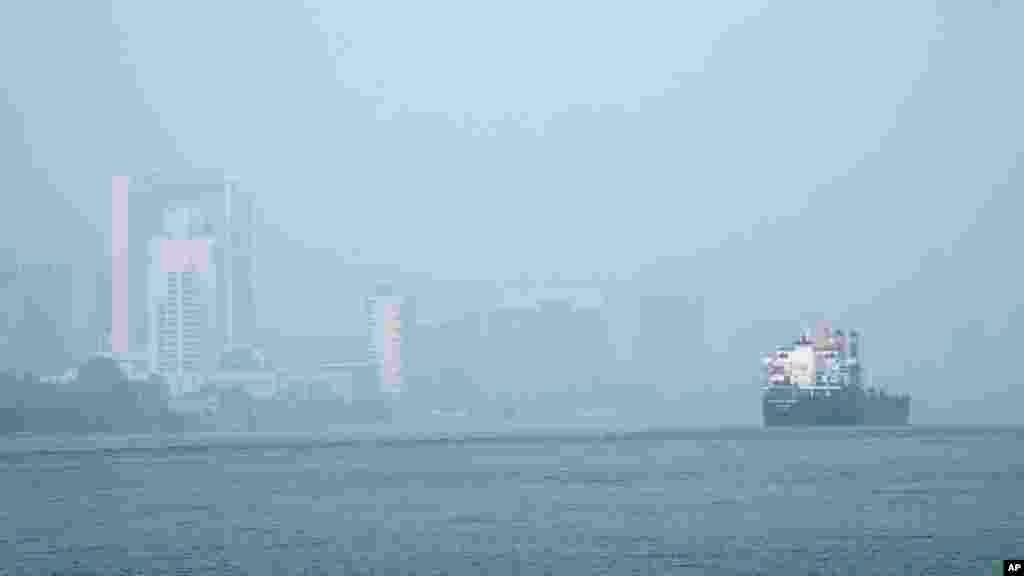A freighter passes through the Detroit River as smoke fills the sky reducing visibility to Windsor, Ontario, Canada, as seen from Detroit.