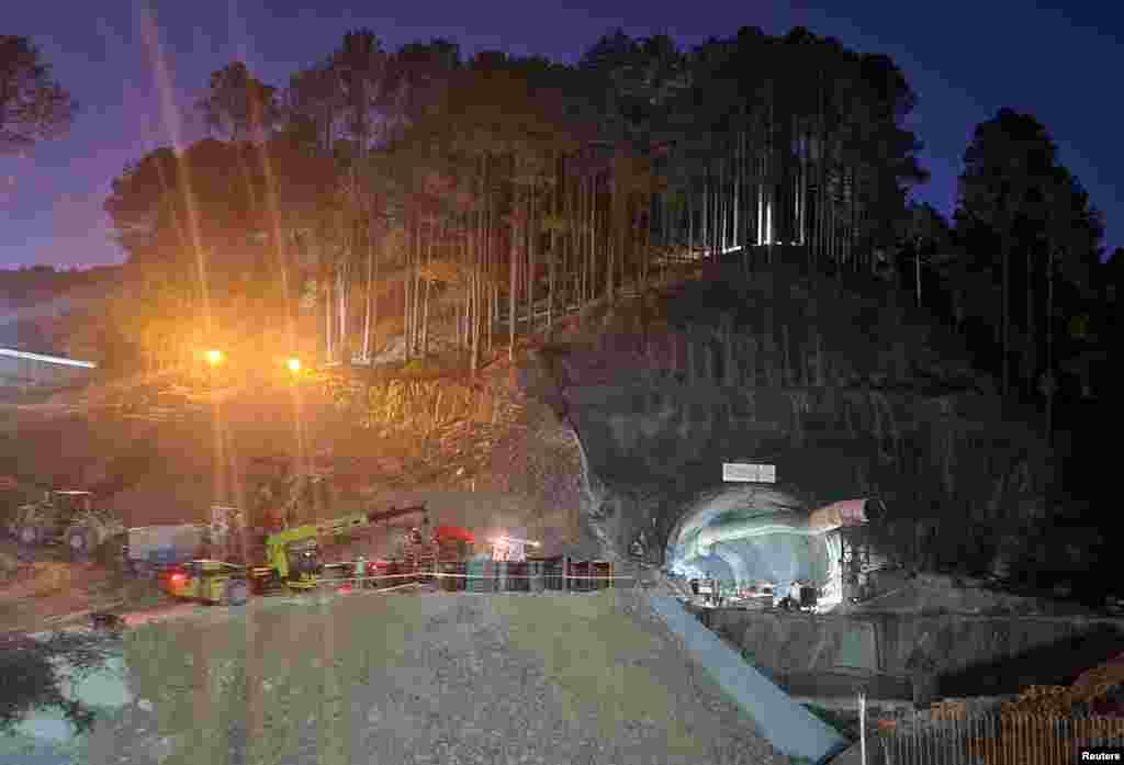 Rescuers move machines past a tunnel where workers are trapped after a portion of the tunnel collapsed in Uttarkashi in the northern state of Uttarakhand, India.