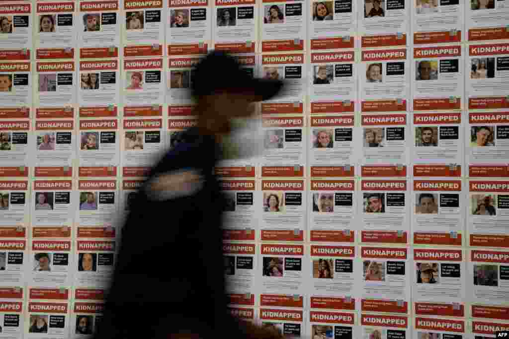 worker walks past "Kidnapped" fliers, displayed as members of the U.S. House of Representatives arrive to view graphic footage from the Oct. 7, 2023, Hamas attack in Israel, shown by the U.S. House Foreign Affairs Committee, on Capitol Hill.