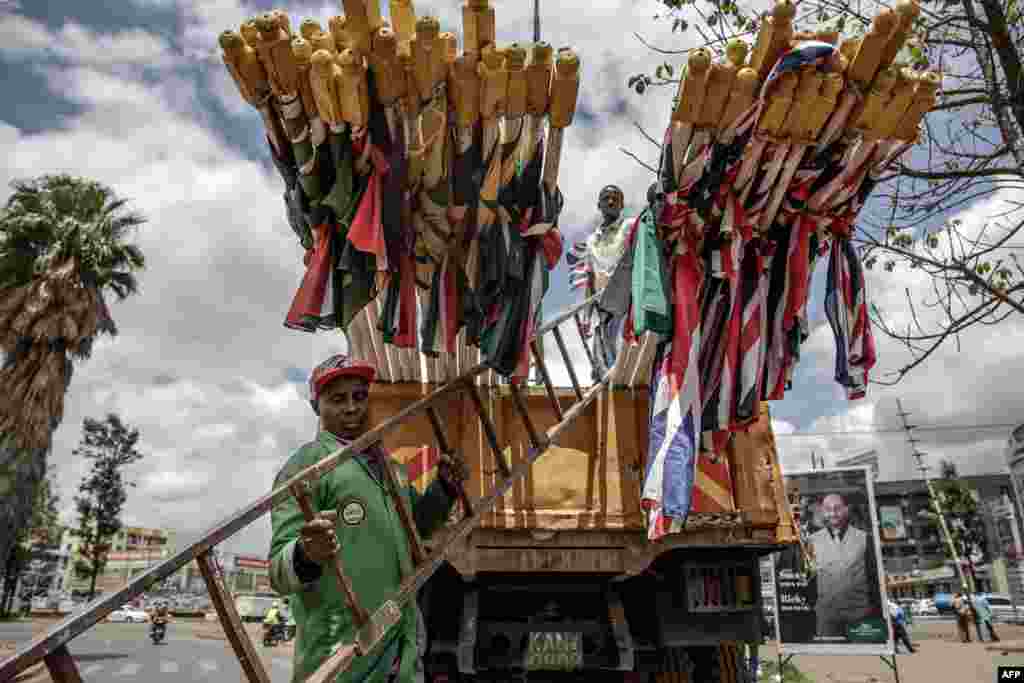 Nairobi City County workers get ready to unload flags of Kenya and the United Kingdom from a truck in Nairobi ahead of the Britain&#39;s monarch visit to Kenya.