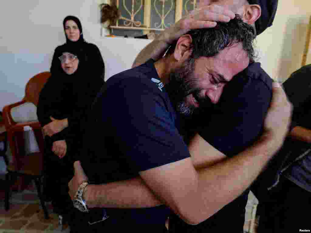 A family member of three Lebanese girls, who were killed along with their grandmother in what Lebanese authorities said was an Israeli strike that hit their car on Sunday, mourns them ahead of their funeral, in the southern town of Aynata, Lebanon.