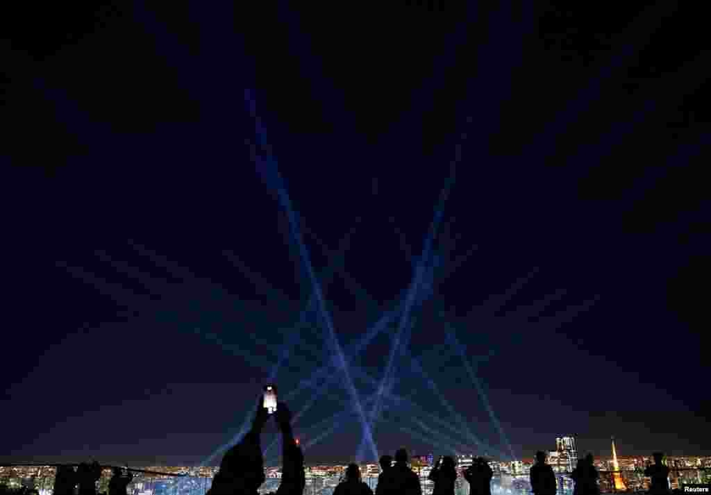 Visitors watch the "Sparkling Light Tree," a light show to celebrate Christmas, at the Shibuya Sky observation deck in Tokyo, Japan.