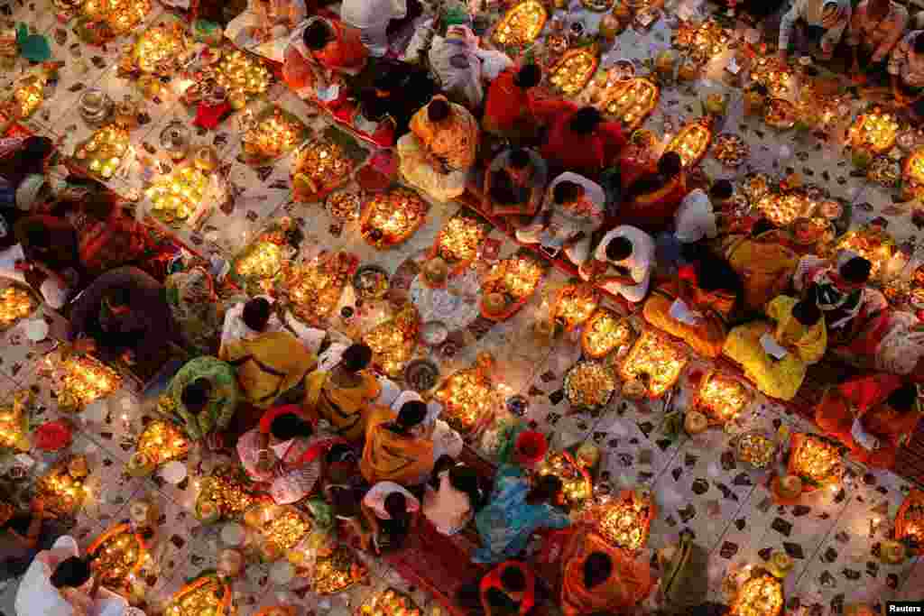 Hindu devotees sit together on the floor of a temple while praying to Lokenath Brahmachari, a Hindu saint, as they observe Rakher Upabash, in Dhaka, Bangladesh.