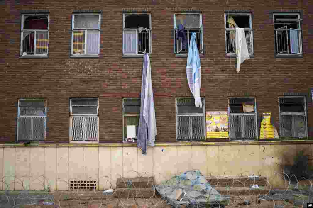 Curtains and sheets used by people trying to flee one of South Africa's deadliest inner-city fires dangle from windows, in Johannesburg, South Africa.
