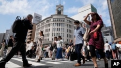 FILE - People walk across a street at the Ginza district of Tokyo, Japan, Tuesday, May 21, 2024.(AP Photo/Shuji Kajiyama)(AP Photo/Shuji Kajiyama)