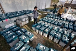 FILE - Election officials gather at a distribution center to receive electronic voting machines and other polling material during polling for Uttar Pradesh state elections in Lucknow, India, Tuesday, Feb. 22, 2022. (AP Photo/Rajesh Kumar Singh, File)
