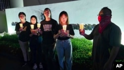 In this image taken and provided by Anti-Death Penalty Asia Network, members of Anti-Death Penalty Asia Network (ADPAN) hold candle outside Singapore Embassy in Kuala Lumpur, Malaysia Wednesday, April 26, 2023. (ADPAN via AP)