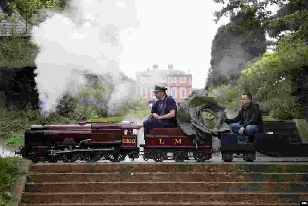 Steam engine driver Bob Corrie, left, and grower Paul Proud transport Proud's cabbage that won its category in the giant vegetable competition at the Harrogate Autumn Flower Show held at Newby Hall country house, near Ripon, northern England.
