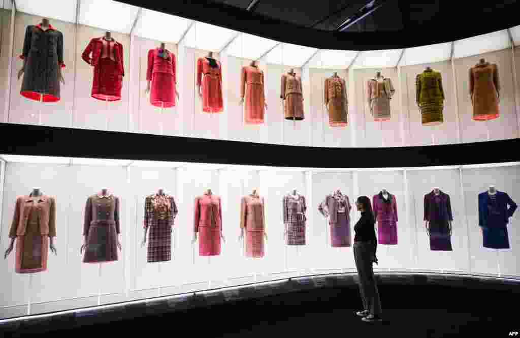 A member of staff looks at the different dresses and outfits displayed during the press photocall for the exhibition "Gabrielle Chanel, Fashion Manifesto" at the V&A museum in London, Sept. 12, 2023. "Gabrielle Chanel, Fashion Manifesto" is the first UK major exhibition dedicated to the work of the pioneering French fashion designer. It will run from Sept. 16, 2023 to Feb. 25, 2024. 