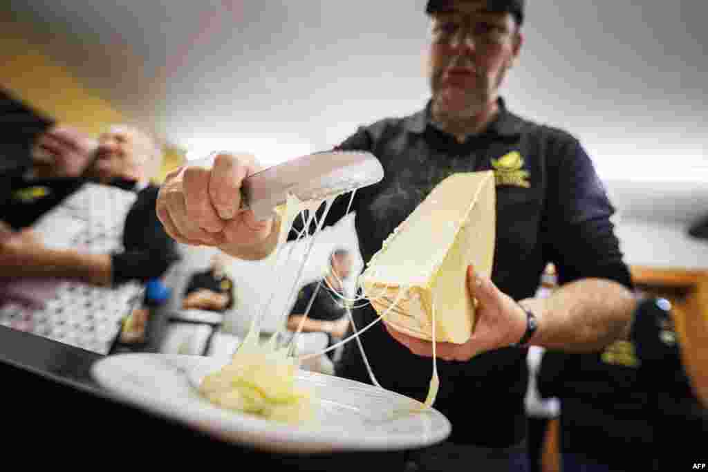 A "scaper" prepares a raclette during the first-ever Raclette World Championships featuring local and international raclette cheeses, in Morgins, Switzerland, Oct. 28, 2023.