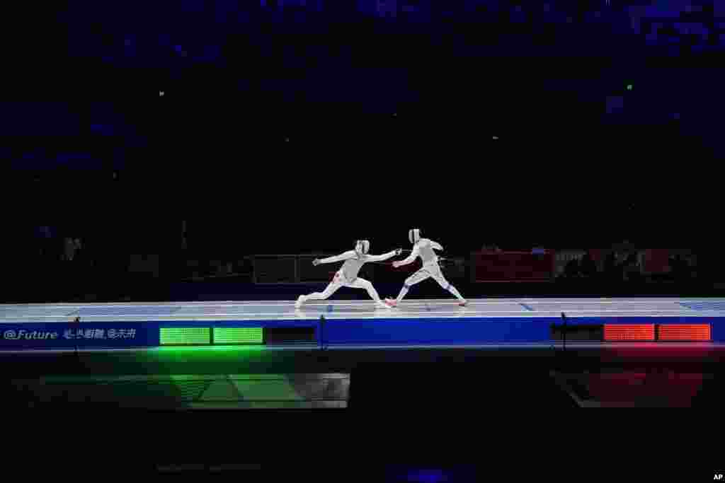 Ka Long Cheung of Hong Kong, left, competes with Haiwei Chen of China in the men's foil individual fencing final at the Hangzhou Dianzi University Gymnasium in the 19th Asian Games in Hangzhou, China.