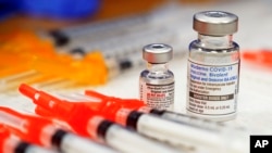 Pfizer and Moderna bivalent COVID-19 vaccines are readied for use at a clinic, Nov. 17, 2022, in Richmond, Va. (AP Photo/Steve Helber, File)