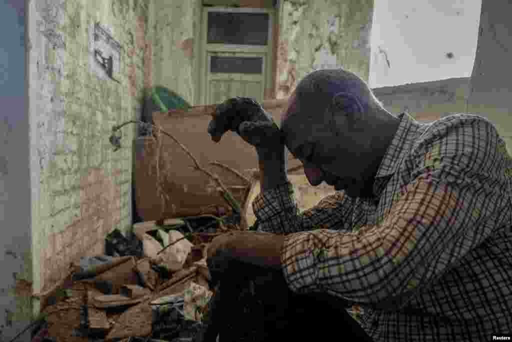 Hassan Kassar, 69, who said he lost his daughters, two of his sons and his granddaughter when a deadly storm hit the city, sits inside his damaged house, in Derna, Libya, Sept. 17, 2023. Some 11,300 people died when two dams collapsed during Mediterranean storm Daniel, sending a wall of water gushing through the city, according to the Red Crescent aid group.