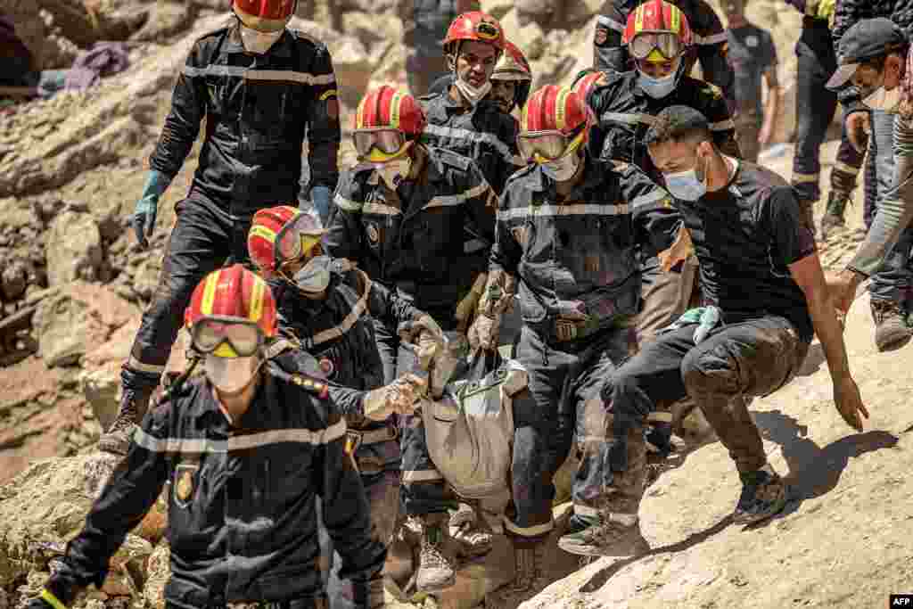 Rescue workers carry a body recovered from the rubble of an earthquake-damaged house in Imi N'Tala village near Amizmiz, Morocco. Rescue teams stepped up a massive effort to bring relief to devastated mountain villages as the chances faded fast for finding survivors from the powerful earthquake which killed 2,900 people and left hundreds of thousands homeless.