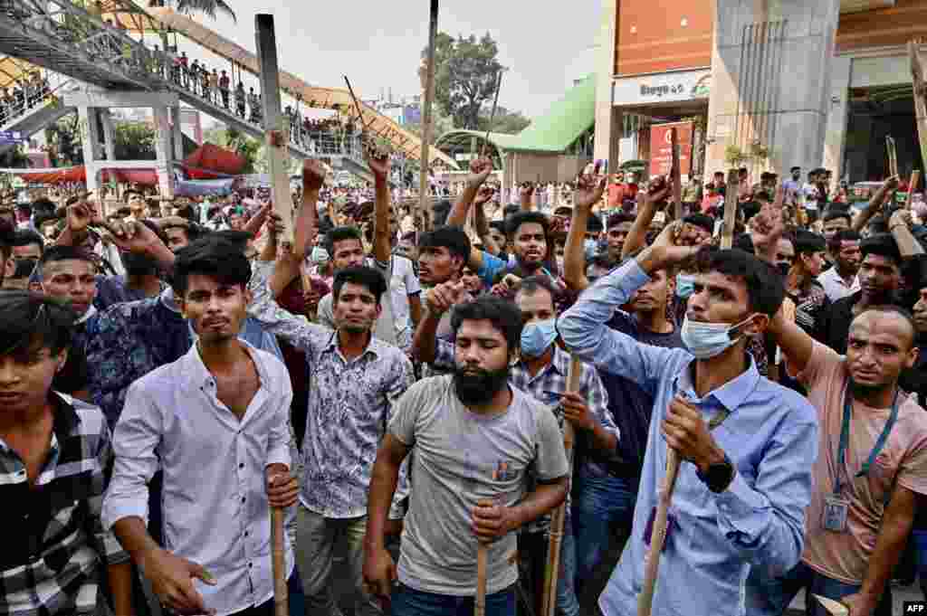 Garment workers block roads as they take part in a protest in Dhaka, Bangladesh. Thousands of Bangladeshi garment workers barricaded roads, demanding fair wages for clothing they make for major Western brands.
