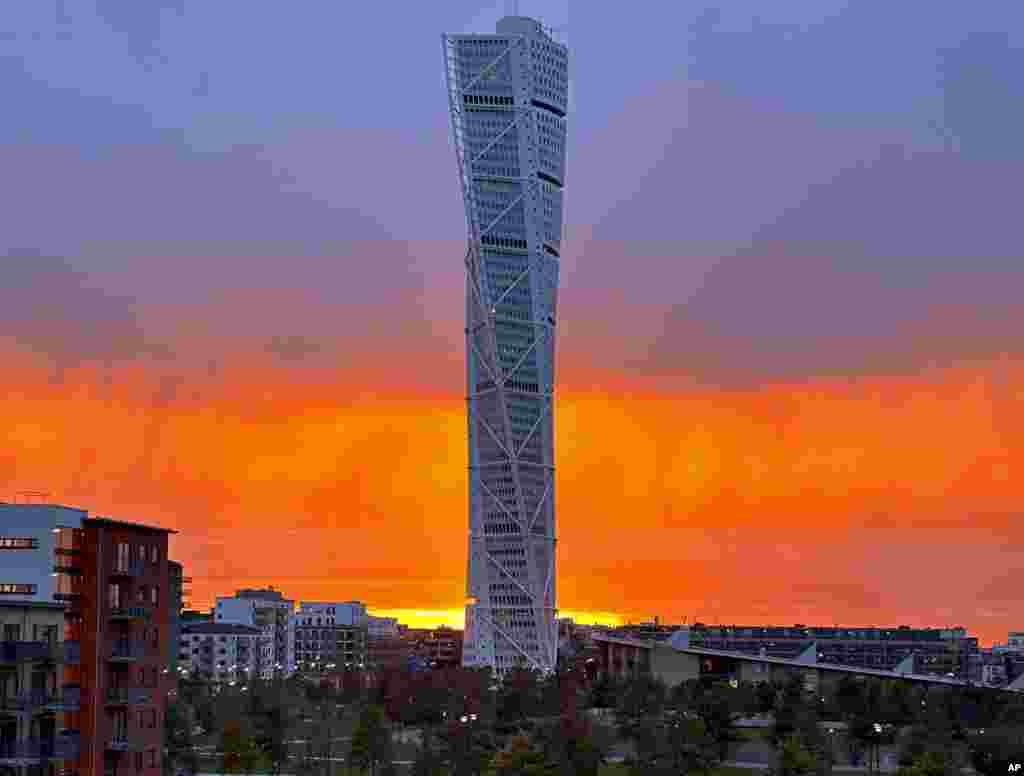 The sun sets behind the 'Turning Torso' skyscraper in Malmoe, Sweden.