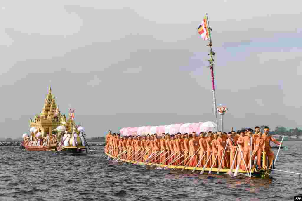 Devotees row in front of the four sacred Buddha images placed on a golden barge (L) during the festival of Phaung Daw Oo Pagoda in Inle Lake, Myanmar's Shan State. Thousands of Buddhist devotees joined a waterborne procession as one of the country's biggest festivals returned to joy and sorrow as conflict between the military and its opponents rages on. 