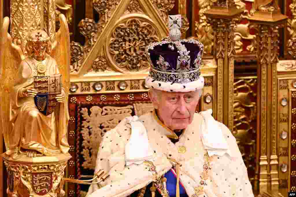 Britain's King Charles III, wearing the Imperial State Crown and the Robe of State, sits on The Sovereign's Throne in the House of Lords chamber, during the State Opening of Parliament, at the Houses of Parliament, in London.
