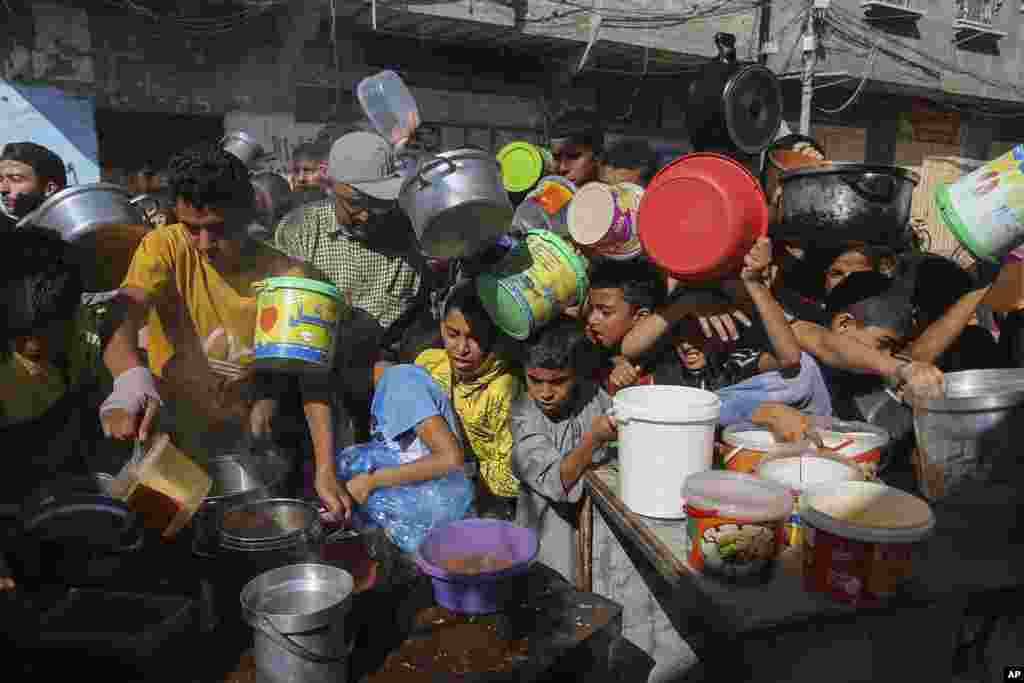 Palestinians crowded together as they wait for food distribution in Rafah, southern Gaza Strip. Since the start of the Israel-Hamas war, Israel has limited the amount of food and water allowed to enter the territory, causing widespread hunger across the strip.