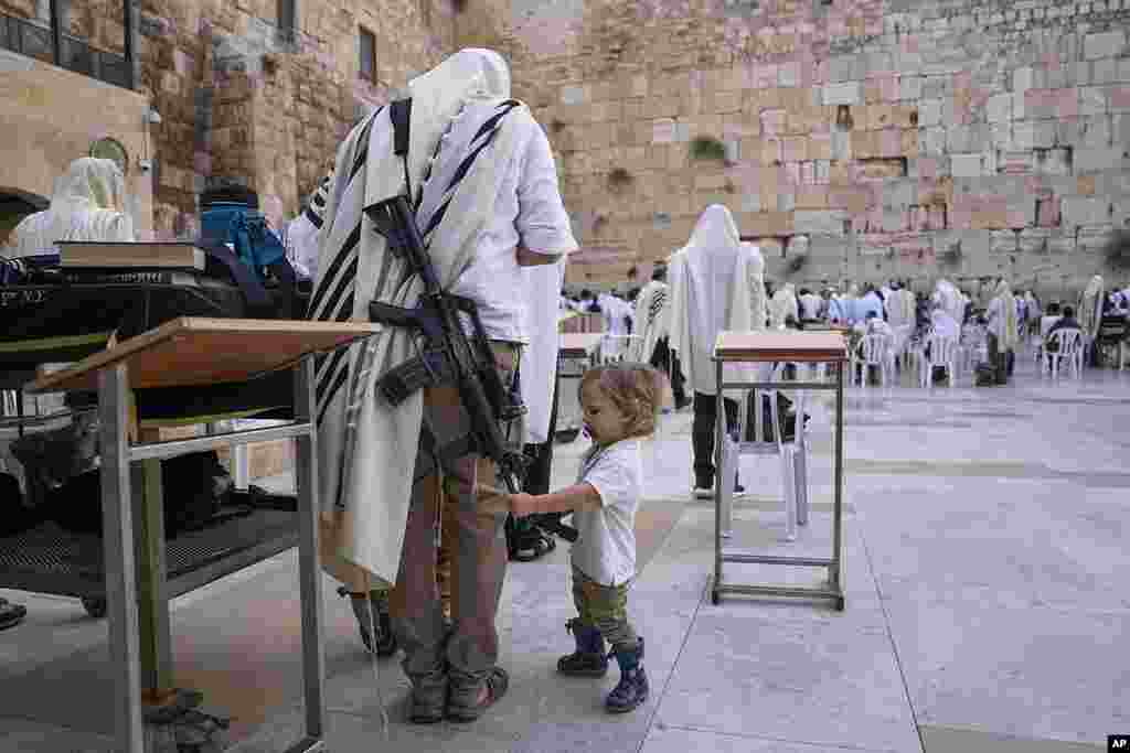 An off-duty member of Israel's security forces joins worshippers at the Western Wall, the holiest site where Jews can pray, in the Old City of Jerusalem.