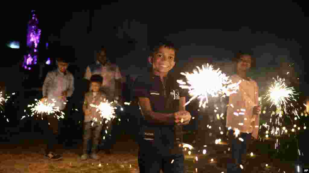Children play with firecrackers at Madan Mohan Malviya Stadium as part of festivities celebrating Diwali festival in Prayagraj, India. Diwali, the annual Hindu festival of lights, will be celebrated on Nov. 12.