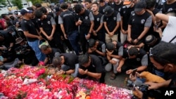 Players and officials of the soccer club Arema FC pray outside the Kanjuruhan Stadium where many fans lost their lives in a stampede Saturday night in Malang, Indonesia, Oct. 3, 2022. (AP Photo/Achmad Ibrahim)