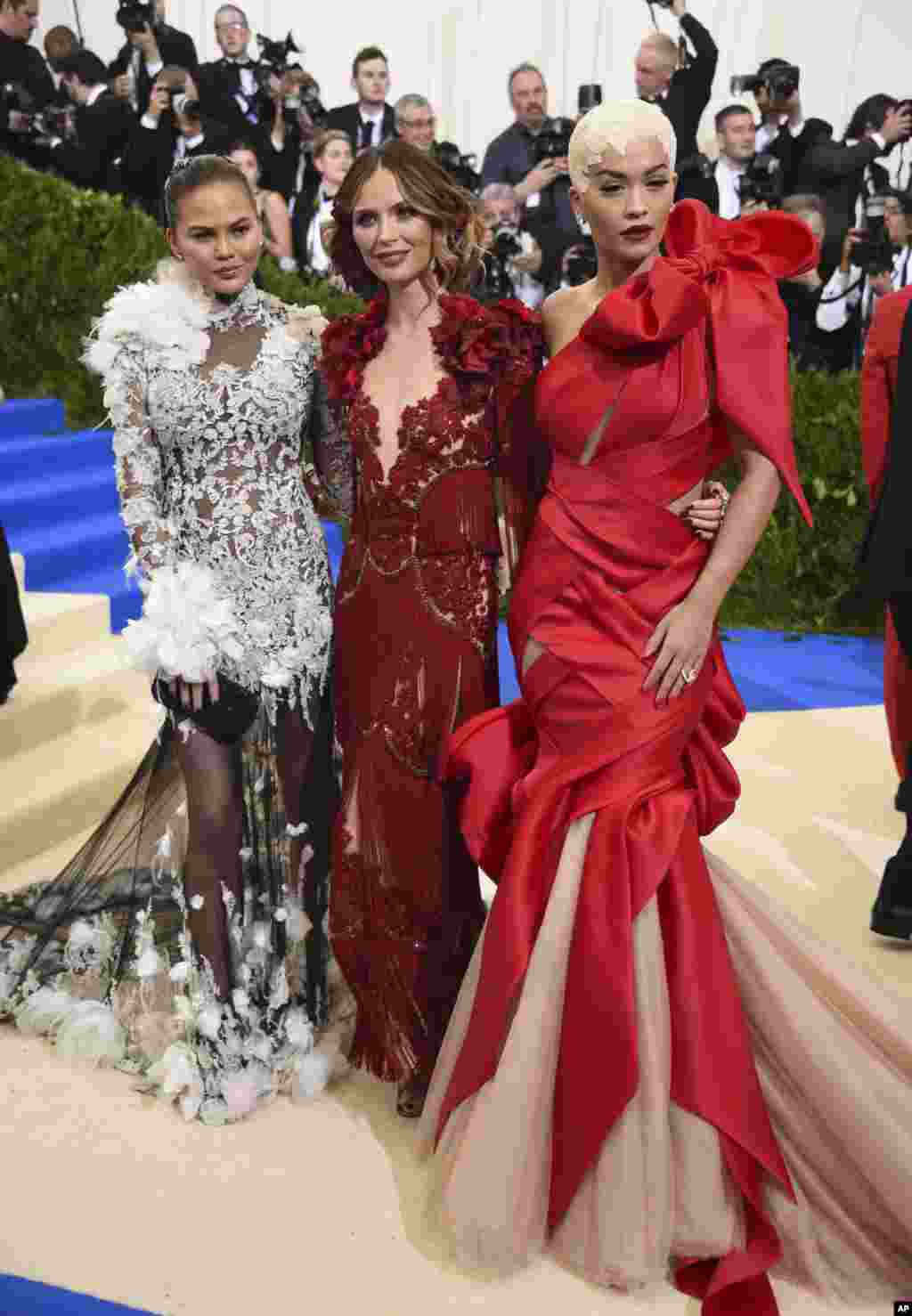 从左至右:美国模特克莉茜·泰根(Chrissy Teigen)、著名红毯战衣品牌玛切萨 (Marchesa) 创始人乔治娜·查普曼(Georgina Chapman)和英国歌手、词曲作者、演员瑞塔·奥拉(Rita Ora) 参加在纽约大都会博物馆举办的时装馆慈善晚会,庆祝"中间的艺术"展览开幕。(2017年5月1日)