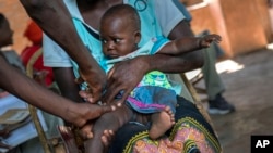 A baby from the Malawi village of Tomali is injected with the world's first vaccine against malaria in a pilot program, in Tomali, Dec. 11, 2019. (AP Photo/Jerome Delay, File)