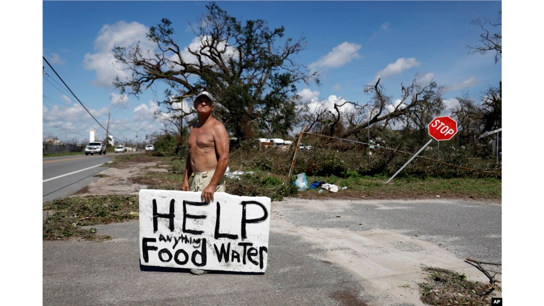 Michael Williams, 70, looks for help from passing motorists as downed trees prevent him from driving out of his damaged home in the aftermath of Hurricane Michael, in Springfield, Florida, Oct. 11, 2018.