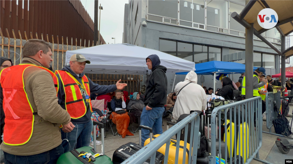 Un grupo de voluntarios ucranianos coordina la entrada en la garita de San Ysidro el 5 de abril de 2022, un día antes de que el Gobierno de Estados Unidos abriera la garita de El Chaparral para agilizar la entrada de los refugiados ucranianos.(Tijuana, México-Abril 5, 2022-Celia Mendoza)