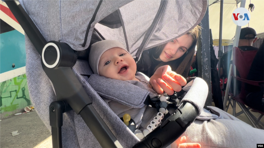 Mark, un bebé ucraniano de meses, espera en su coche junto a su mamá, afuera de la puerta de entrada de la garita de Otay en Tijuana, donde fue ampliado el acceso para recibir y procesar ucranianos a principios de abril, tras aumentar el número de refugiados de la guerra que empezaron a llegar a esta frontera. (Tijuana, México-April 4, 2022-Celia Mendoza)