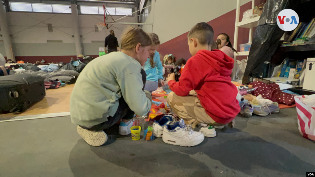 Un grupo de niños ucranianos juegan en el área para dormir en la Unidad Deportiva Benito Juárez, donde los voluntarios han creado una esquina con libros infantiles, juguetes y actividades de aprendizaje. (Tijuana, México-April 4, 2022-Celia Mendoza)