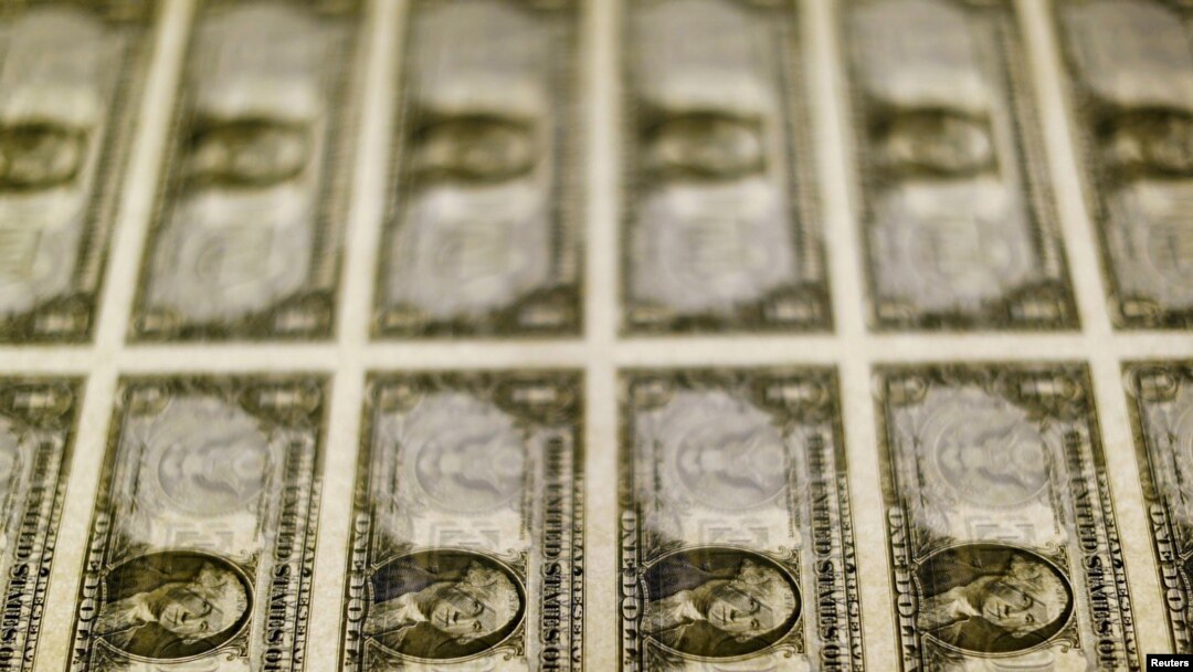 FILE - United States one dollar bills are seen on a light table at the Bureau of Engraving and Printing in Washington, Nov. 14, 2014. 