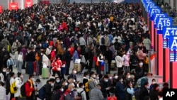 Na ovoj fotografiji koju je objavila novinska agencija Xinhua, ljudi se spremaju da uhvate svoje vozove na sjevernoj željezničkoj stanici u Shenzhenu u južnoj kineskoj provinciji Guangdong, subota, 7. januara 2023. 