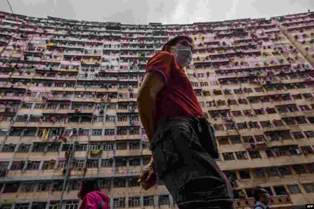 People walk past a residential building in Hong Kong.