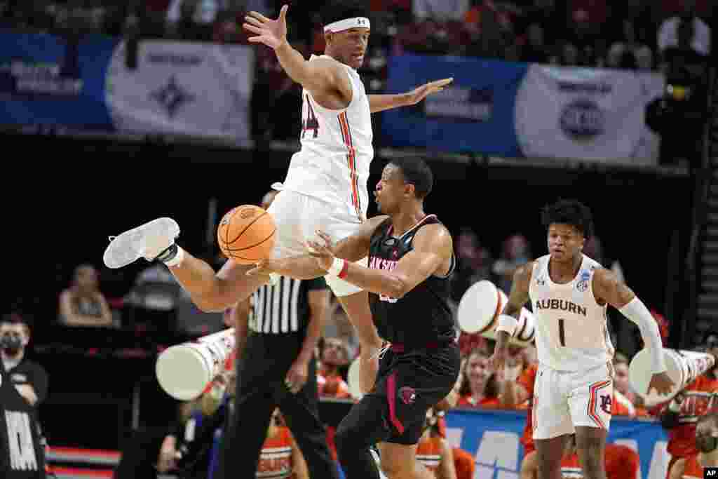 Jacksonville State's Darian Adams (23) passes the ball as Auburn's Dylan Cardwell (44) defends during the first half of a college basketball game in the first round of the NCAA tournament in Greenville, S.C.