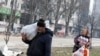 Residentes locales que llevan alimentos pasan frente un edificio de apartamentos dañado por bombardeos rusos en la sitiada ciudad portuaria de Mariupol, en el sur de Ucrania, el 31 de marzo de 2022. REUTERS/Alexander Ermochenko