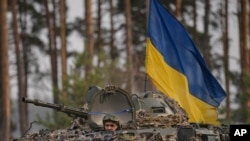 Las tropas ucranianas en un vehículo blindado avanzan en las afueras de Kiev, Ucrania, el 31 de marzo de 2022.