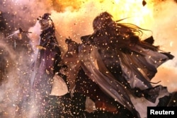 Two Pili puppet characters battle each other, with real fire as a special effect, during a demonstration at their filming studio in Yunlin, Taiwan, February 18, 2022. (REUTERS/Ann Wang)