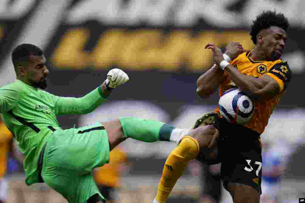 Wolverhampton Wanderers' Adama Traore is hit by Brighton's goalkeeper Robert Sanchez during the English Premier League soccer match between Wolverhampton Wanderers and Brighton & Hove Albion at the Molineux Stadium in Wolverhampton, England.