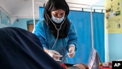 FILE - A Save the Children midwife provides Zarmina, 25, who is five months pregnant, with a pre-natal check-up in Jawzjan province in northern Afghanistan, Sunday, Oct. 2, 2022. (Save the Children via AP, File)