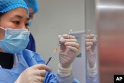 A nurse prepares a shot of COVID-19 vaccine at a community health center in Nantong in eastern China's Jiangsu province on Dec. 9, 2022. (Chinatopix Via AP)