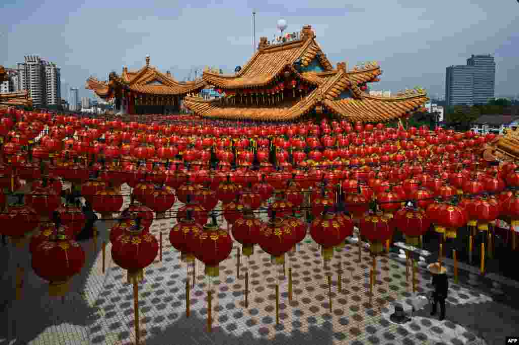 A worker cleans the floor under the red lanterns of Chinese New Year decorations at the Thean Hou Temple ahead of the Lunar New Year celebrations, which mark the year of the rabbit, in Kuala Lumpur, Malaysia.