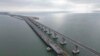 In this handout photo released by the Russian Federal Road Transport Agency (Rosavtodor) on Nov. 8, 2022, workers repair the side of damaged spans of the road section of the Crimean Bridge connecting Russian mainland and Crimean peninsula.
