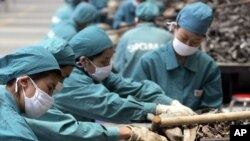 Chinese workers sellect car part scrap to collect aluminum for recycling at a smelting plant Monday, June 6, 2005 in outskirt of Shanghai. China has stopped importing some kinds of recyclable materials.